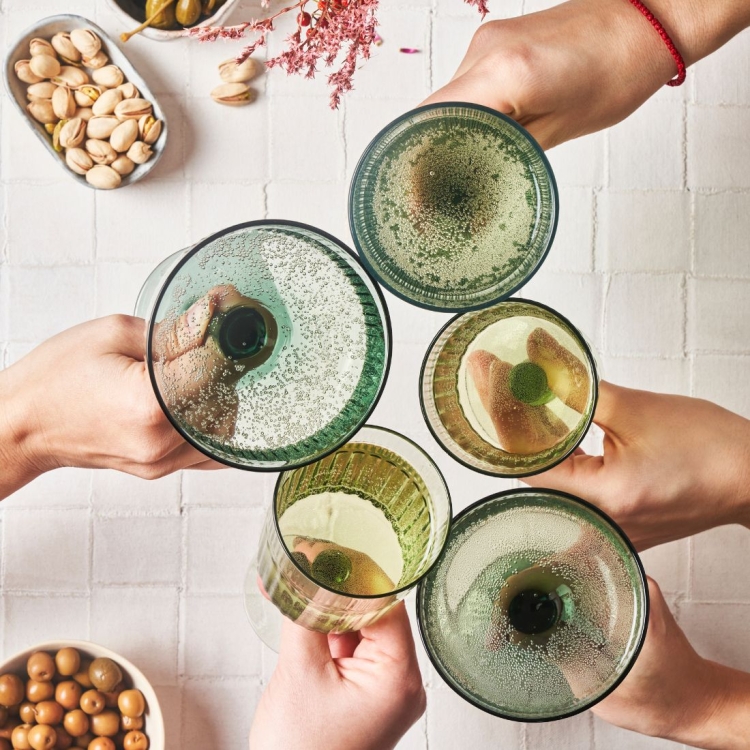 Fünf Personen stoßen mit Champagner Schalen an