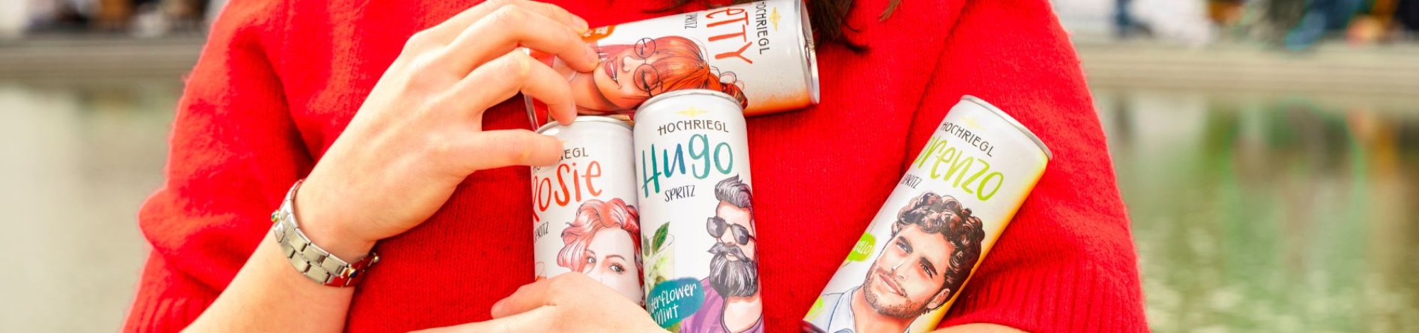 Dame hält vier Hochriegl Spritz Dosen in der Hand